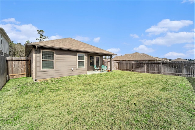 rear view of property with a yard and a patio area