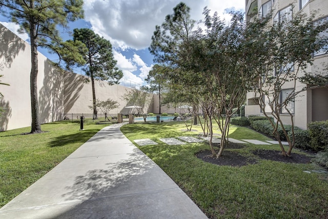 view of home's community featuring a pool and a yard