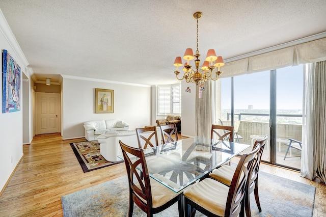 dining space with ornamental molding, a chandelier, light hardwood / wood-style floors, and a textured ceiling