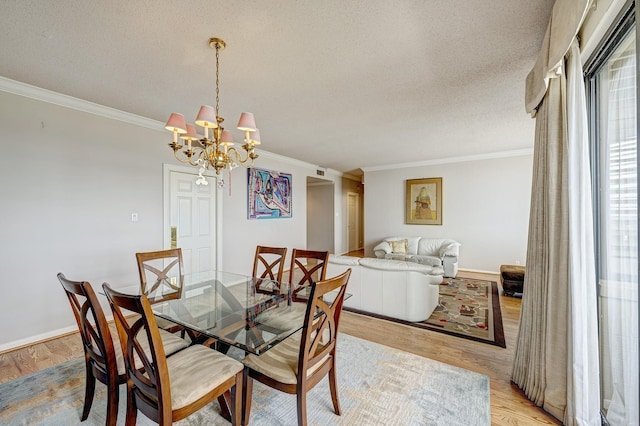 dining room featuring crown molding, a notable chandelier, a textured ceiling, and light wood-type flooring