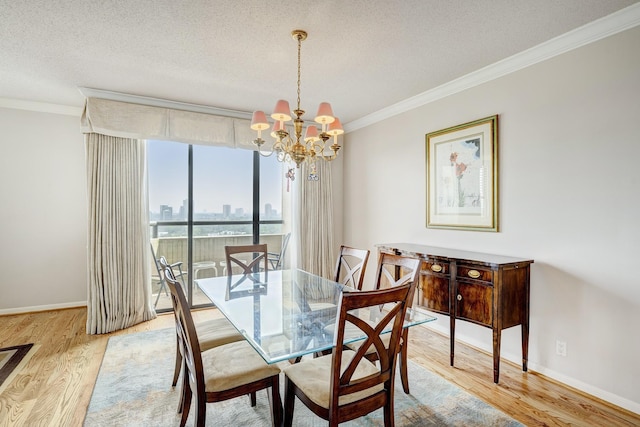 dining room featuring a notable chandelier, ornamental molding, a textured ceiling, and light wood-type flooring