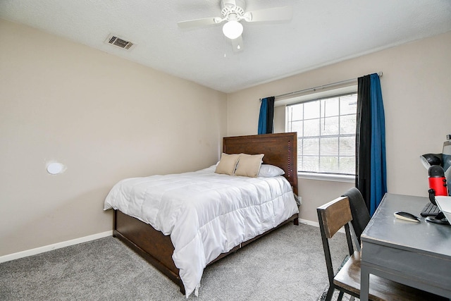 carpeted bedroom featuring a ceiling fan, visible vents, and baseboards