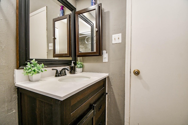 bathroom with a textured wall and vanity