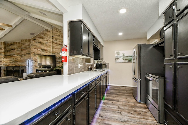 kitchen with electric stove, open floor plan, light countertops, light wood-style floors, and a sink