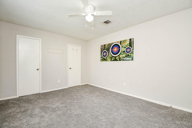 empty room featuring baseboards, a textured ceiling, visible vents, and carpet flooring