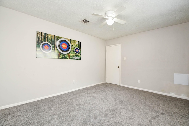 carpeted empty room with a ceiling fan, visible vents, a textured ceiling, and baseboards