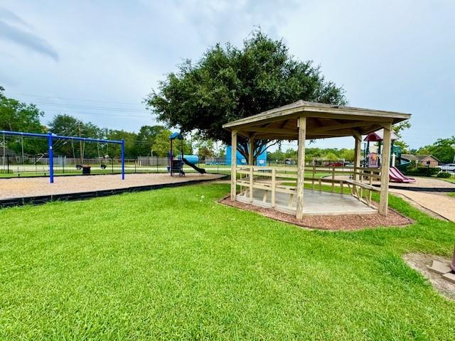 view of home's community with playground community and a yard