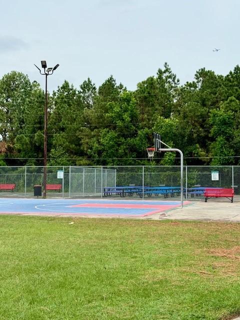 view of sport court featuring community basketball court, fence, and a lawn