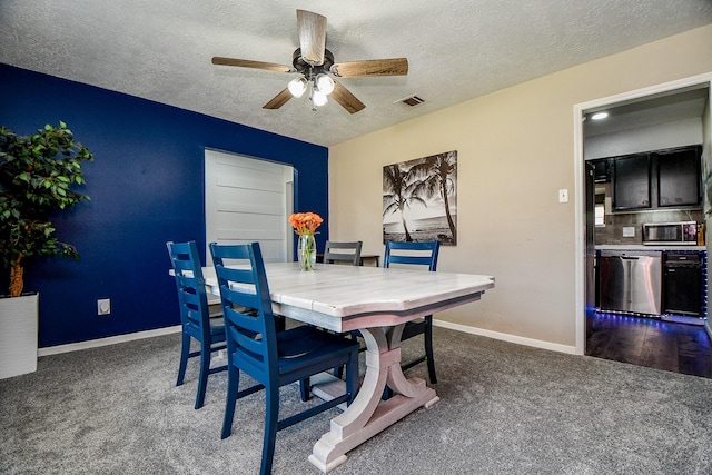 dining space featuring a textured ceiling, dark carpet, a ceiling fan, and baseboards