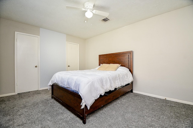 bedroom with visible vents, dark carpet, ceiling fan, a textured ceiling, and baseboards