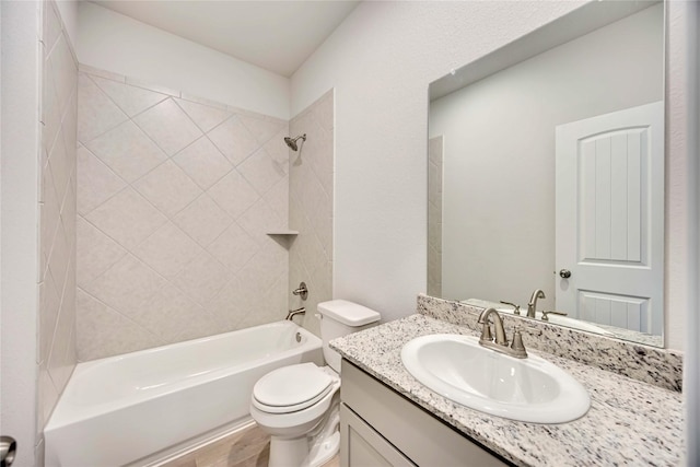 full bathroom featuring tiled shower / bath combo, vanity, and toilet