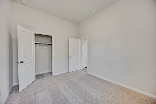 unfurnished bedroom featuring light colored carpet and a closet