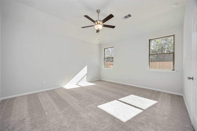 spare room featuring light colored carpet and ceiling fan