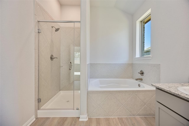 bathroom with independent shower and bath, wood-type flooring, lofted ceiling, and vanity