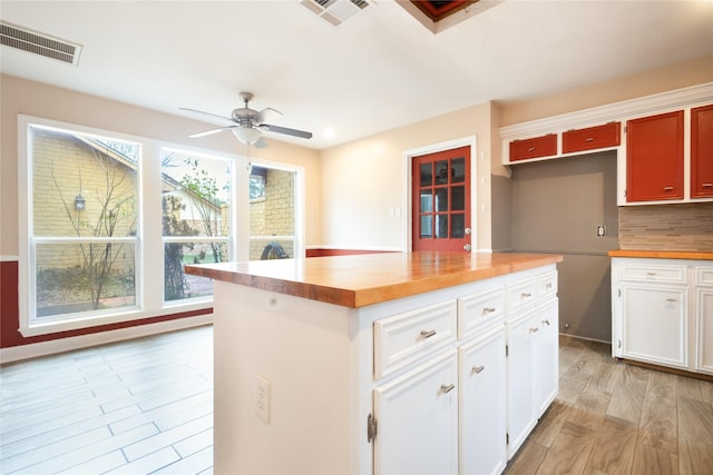 kitchen with ceiling fan, white cabinetry, butcher block counters, tasteful backsplash, and light wood-type flooring