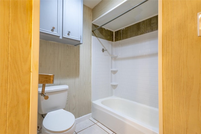 bathroom with tile patterned flooring, tiled shower / bath, and toilet