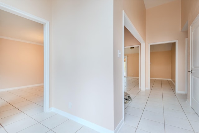 hall featuring crown molding and light tile patterned floors