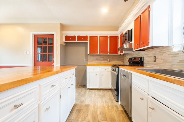 kitchen featuring tasteful backsplash, appliances with stainless steel finishes, extractor fan, and white cabinets