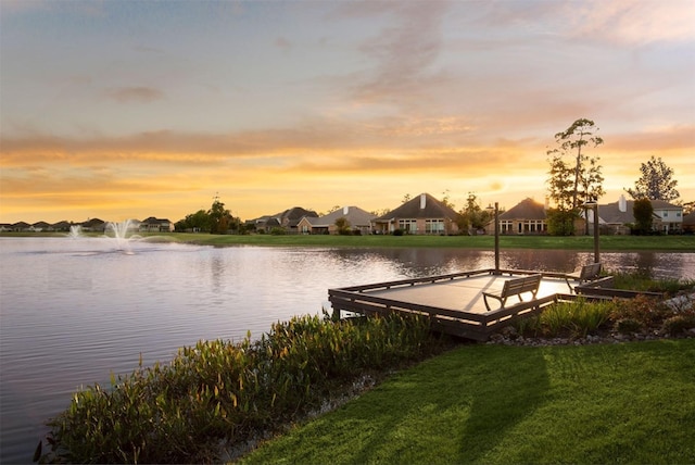 dock area with a water view and a yard