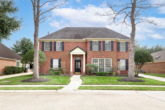 colonial-style house featuring a front lawn