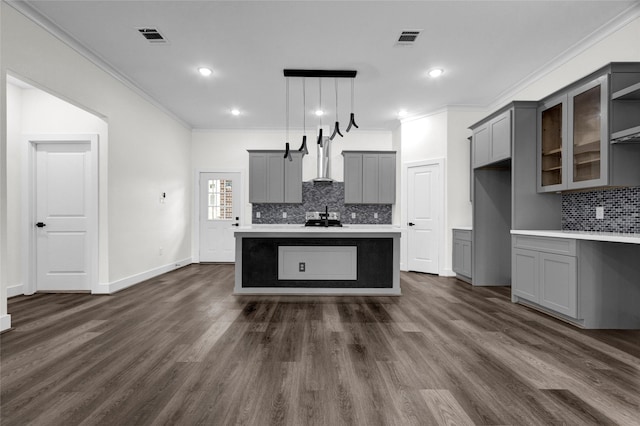 kitchen with gray cabinets, crown molding, wall chimney range hood, and decorative light fixtures