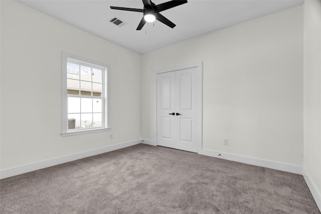 carpeted spare room with ceiling fan