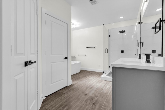 bathroom featuring independent shower and bath, wood-type flooring, and vanity