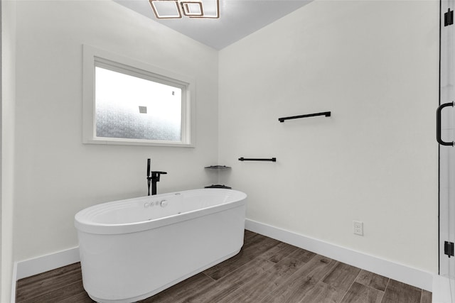 bathroom with wood-type flooring and a washtub