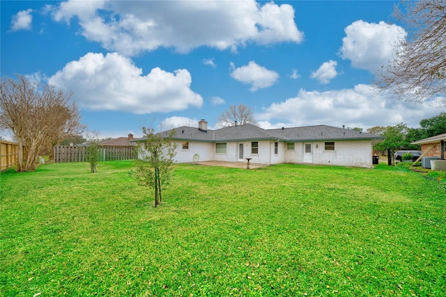 rear view of house with cooling unit, a yard, and a patio area