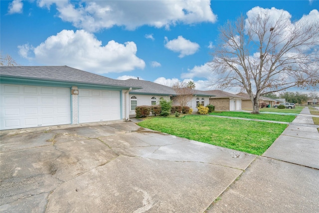 ranch-style home with a garage and a front lawn