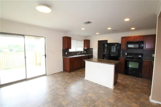 kitchen with sink, decorative backsplash, black appliances, and a center island