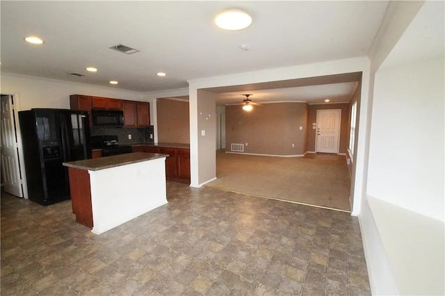 kitchen with crown molding, black appliances, a center island, and decorative backsplash