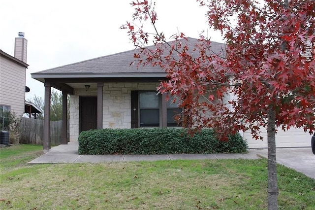 view of front of house with central AC unit and a front yard