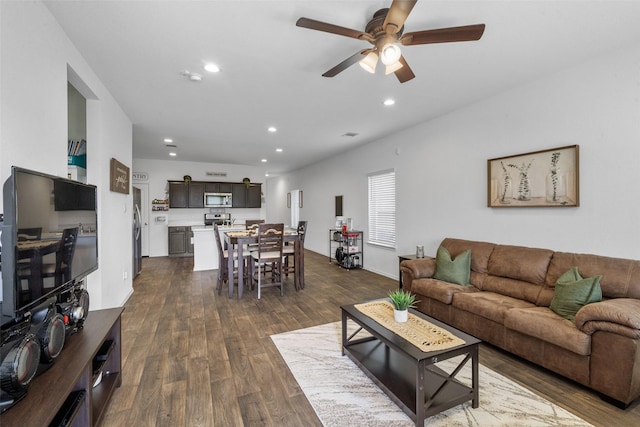 living room featuring dark wood-type flooring and ceiling fan