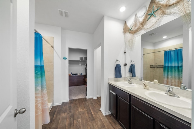 bathroom with wood-type flooring, curtained shower, and vanity