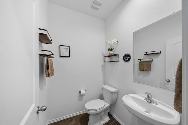 bathroom featuring sink, wood-type flooring, and toilet