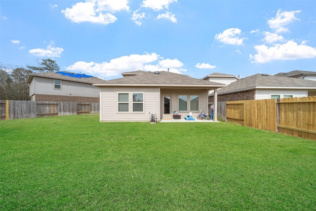 rear view of property with a yard and a patio area