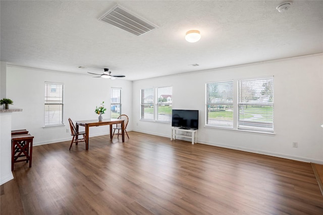 living room featuring ceiling fan, dark hardwood / wood-style floors, and a textured ceiling