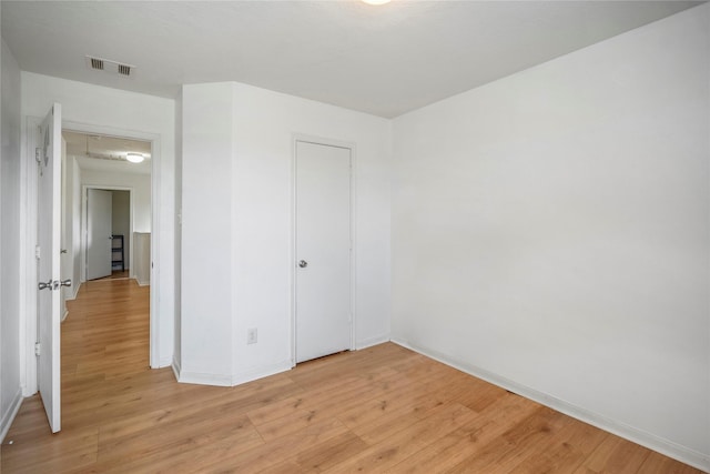 unfurnished bedroom featuring a closet and light wood-type flooring