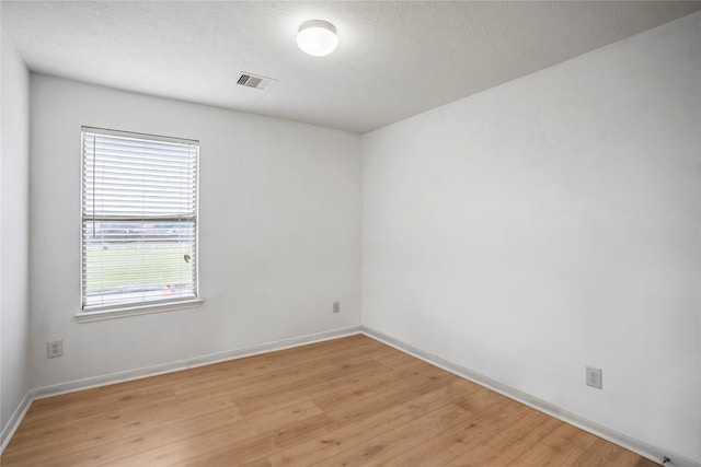 empty room featuring light hardwood / wood-style flooring and a textured ceiling