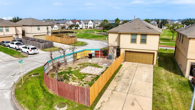 view of front of property featuring a garage, a front lawn, and central air condition unit