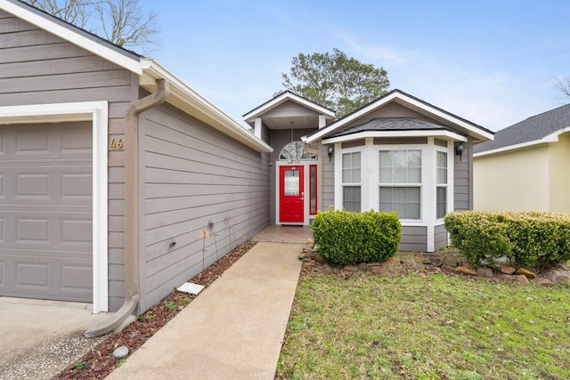 property entrance featuring a garage and a lawn