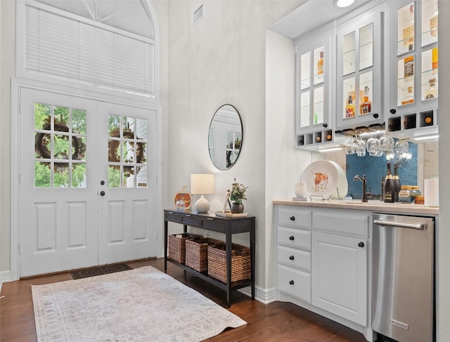 entrance foyer with dark hardwood / wood-style flooring, wet bar, and french doors