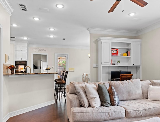 living room with crown molding, dark hardwood / wood-style floors, sink, and ceiling fan