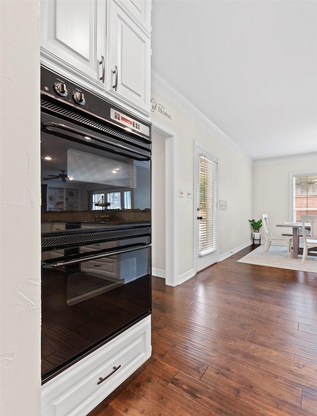 kitchen featuring white cabinetry, double oven, crown molding, and dark hardwood / wood-style flooring