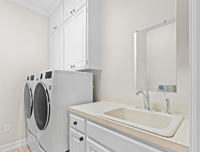 clothes washing area featuring washer and dryer, sink, cabinets, ornamental molding, and light tile patterned floors