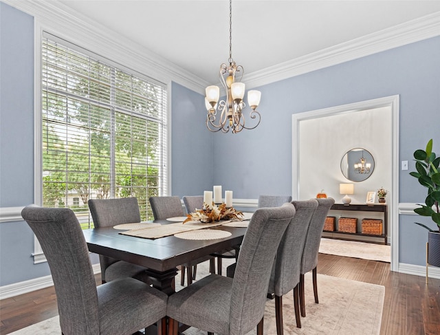 dining area featuring wood-type flooring, ornamental molding, and a chandelier