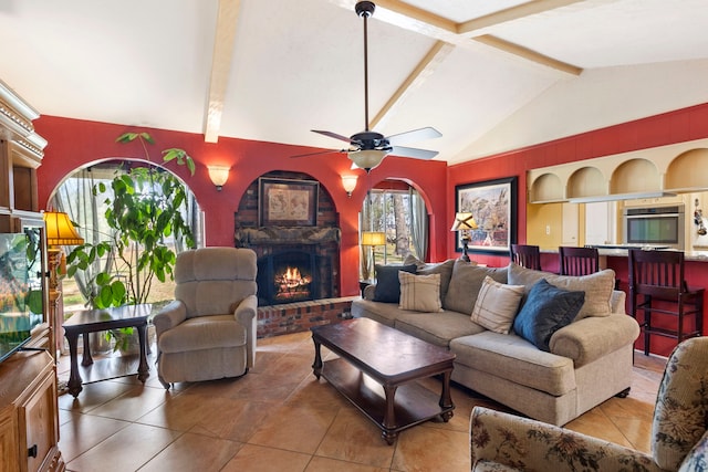 living area featuring lofted ceiling with beams, a brick fireplace, a ceiling fan, and built in features