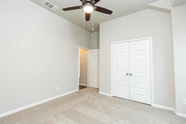 unfurnished bedroom featuring light colored carpet, a closet, and ceiling fan