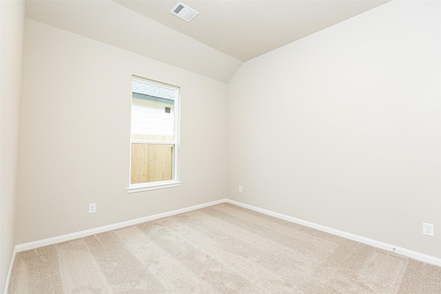 spare room with lofted ceiling and light carpet